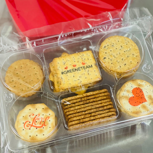 Crackers for cheese boards and charcuterie boards that have hearts and words printed on them.